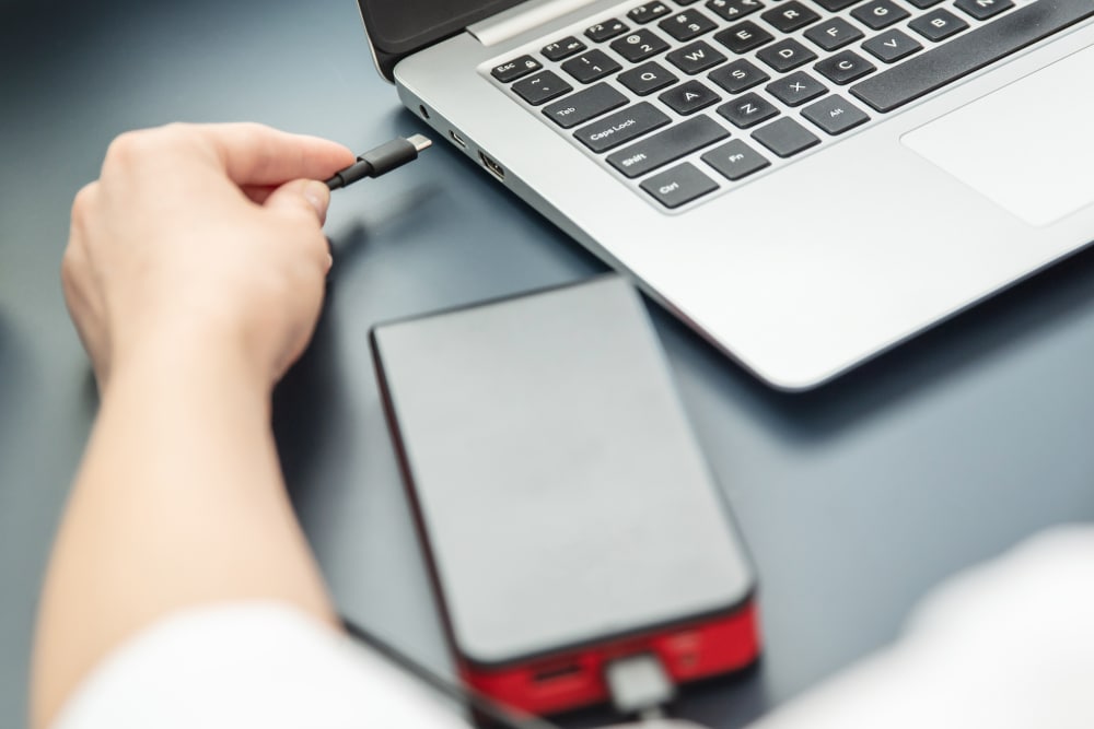 A view of a hand charging the laptop