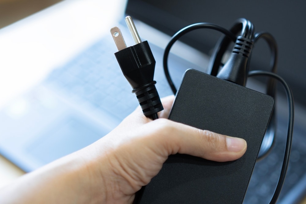 A view of a person holding a laptop charger