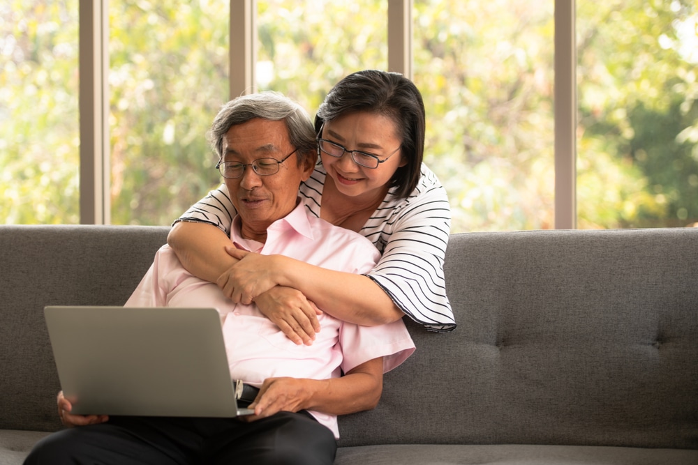 A view of an old couple using laptop