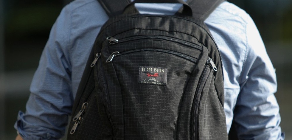 A backview of a person carrying the TOM Bihn Synapse Laptop Bag