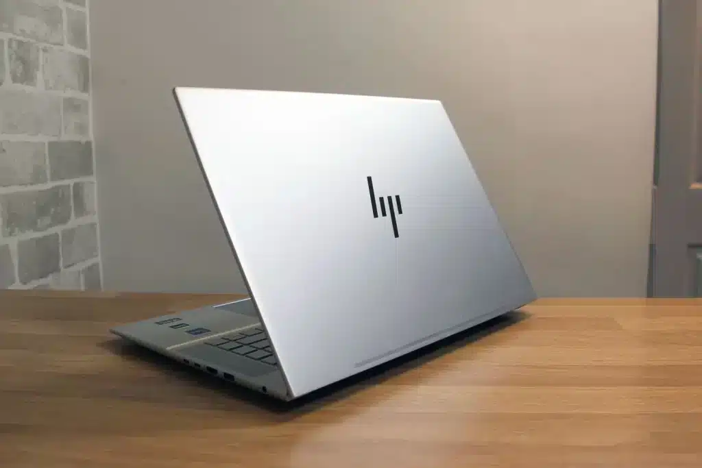 A side view of a half closed Hp laptop from behind