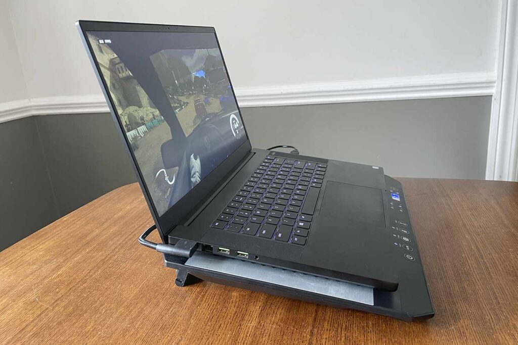 A side view of a laptop placed on a cooling pad on a wooden desk