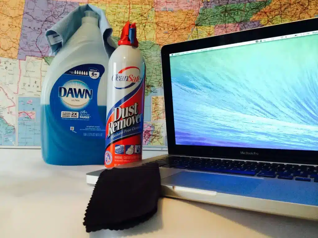 a laptop along with the cleaning liquids and a cloth