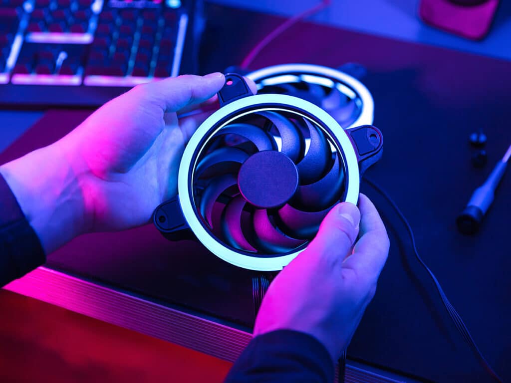 A view of a person holding an LED light fan of laptop