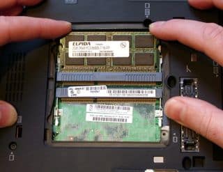 A view of a person putting RAM inside the laptop