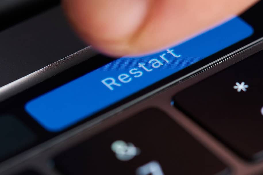 A view of a restart button about to pressed on a laptop