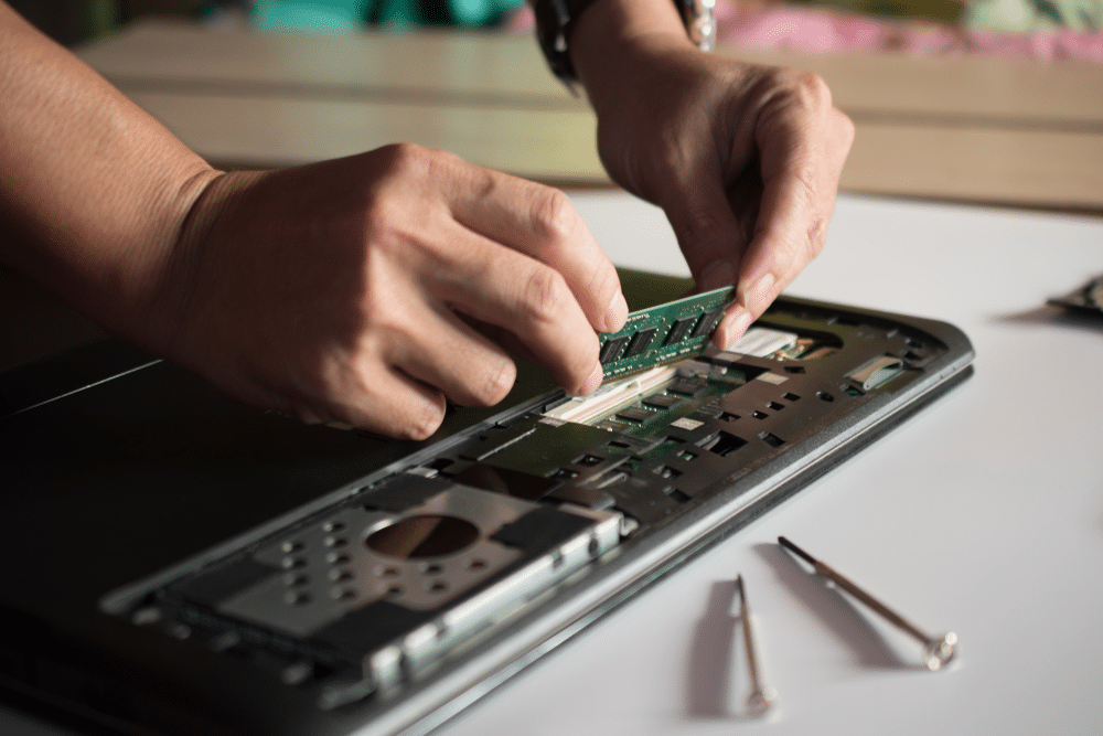 A view of a technician dealing with the motherboard of laptop RAM