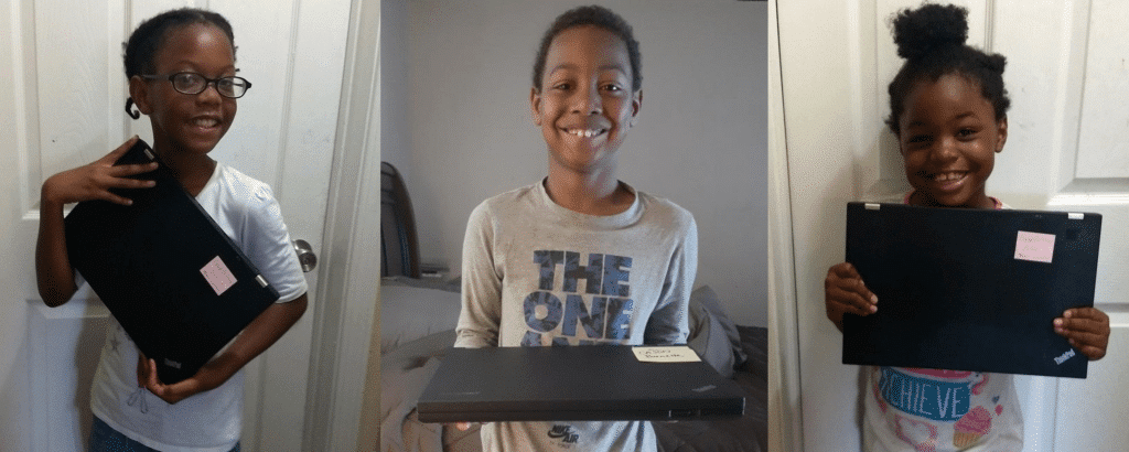 A view of children holding donated laptops