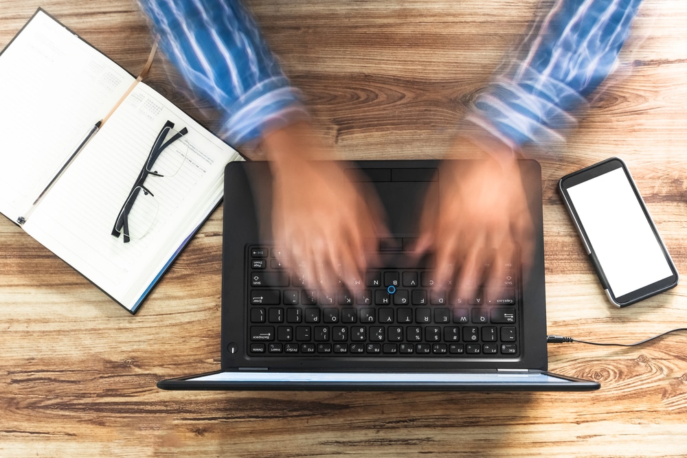 An overhead view of a person using laptop fastly