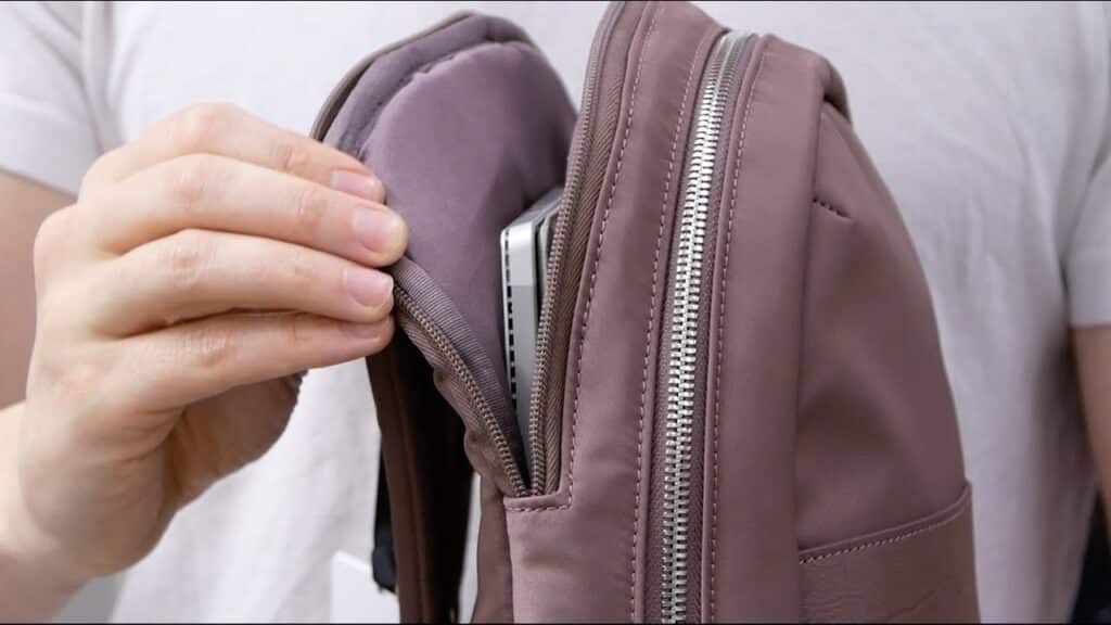 a person holding the laptop bag with the laptop in the baf