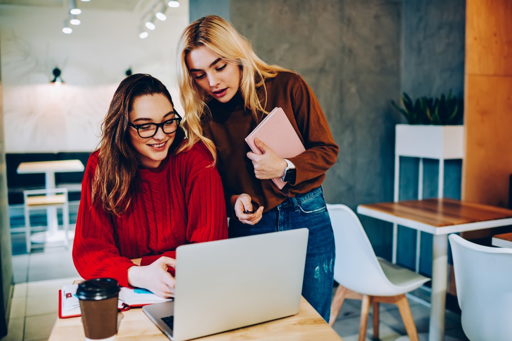 Skilled Female Students Making Research On Laptop Computer Doing Homework